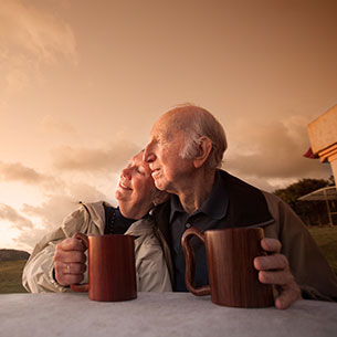 A couple drinking hot drinks outside. Links to Gifts from Retirement Plans